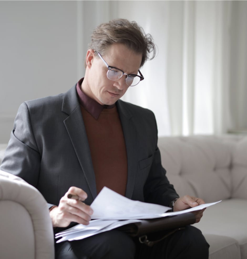 Serious man with glasses reviewing fast inheritance advance documents.