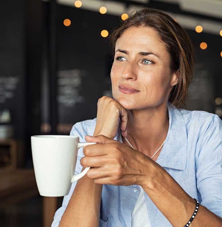 Woman holding a mug thinking about inheritance advance.