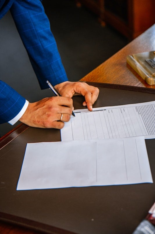 Businessman hands signing an inheritance advance document.